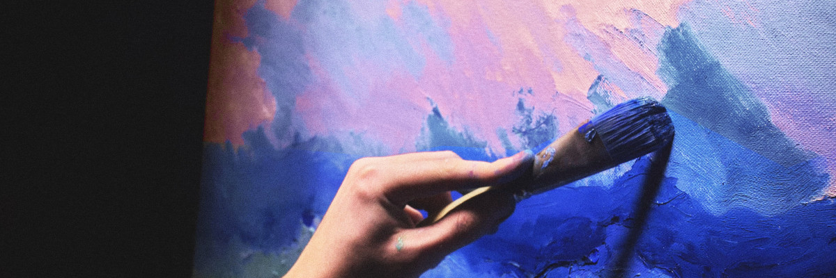 En hand som målar med en pensel. Käsi maalaa siveltimellä.